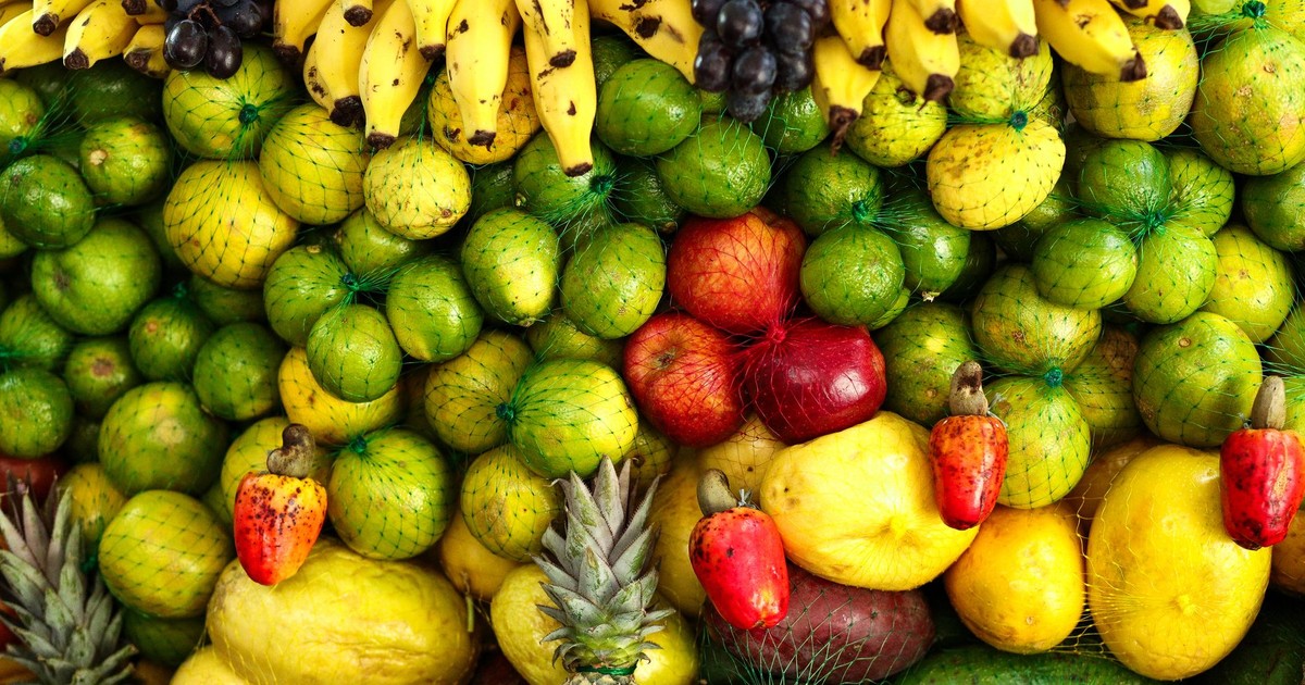 A colorful arrangement of assorted tropical fruits including bananas, apples, pineapples, and citrus.