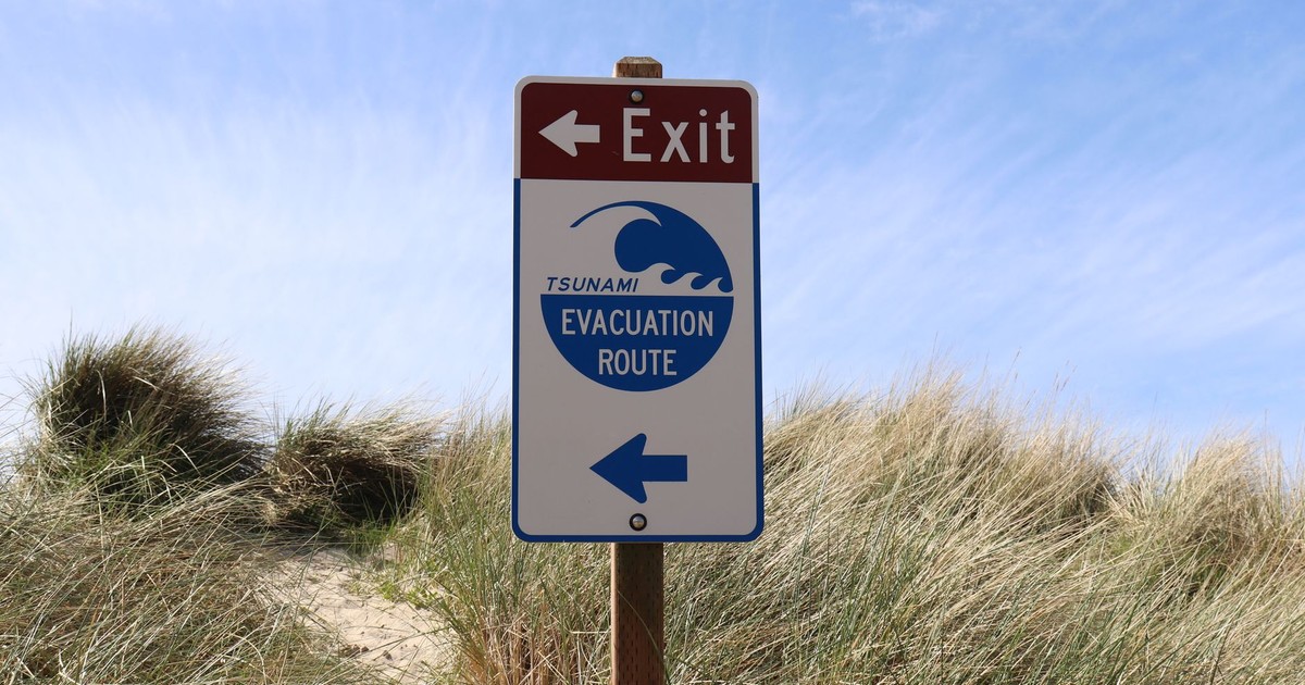 Tsunami evacuation route sign at Cannon Beach, Oregon, guiding beachgoers to safety.