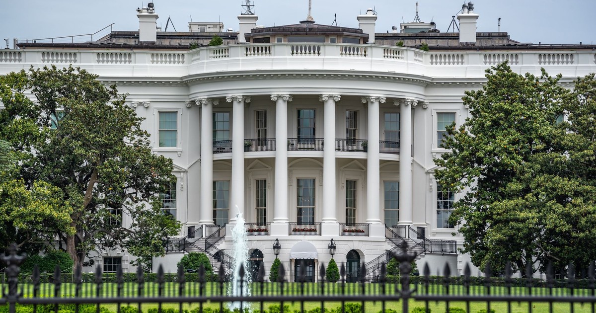 A classic view of the White House in Washington DC with lush greenery and fountains.