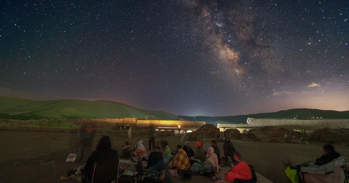 People observing the Milky Way in Takab, Iran, under a starry night sky.