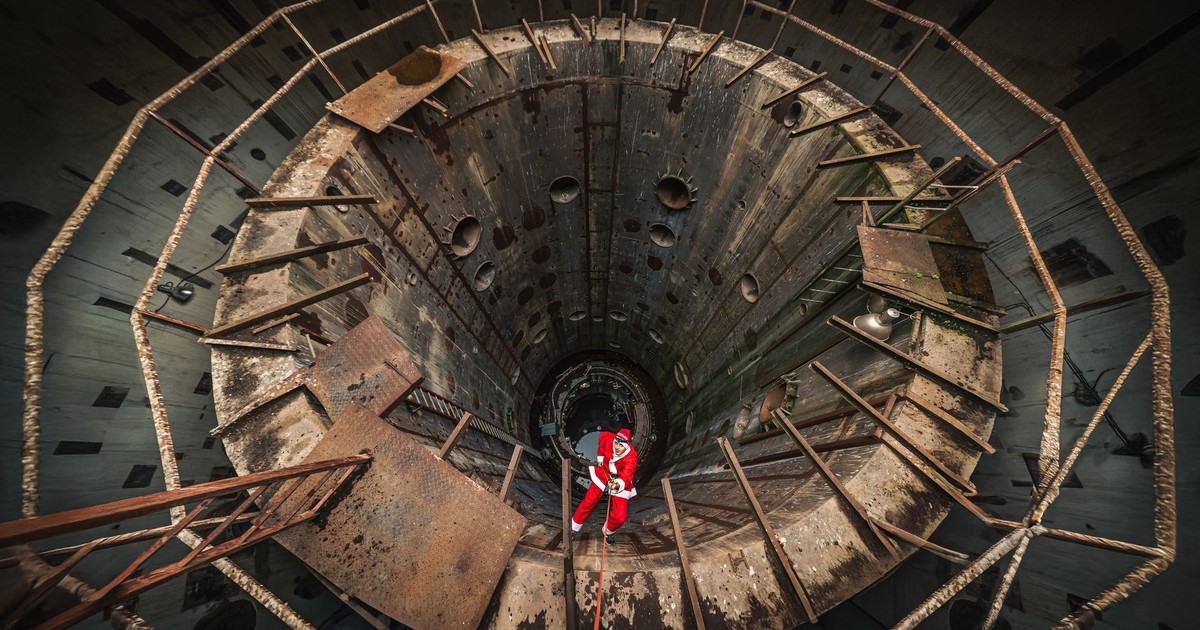 A daring adventurer descends into a massive industrial pit, showcasing bravery and exploration.
