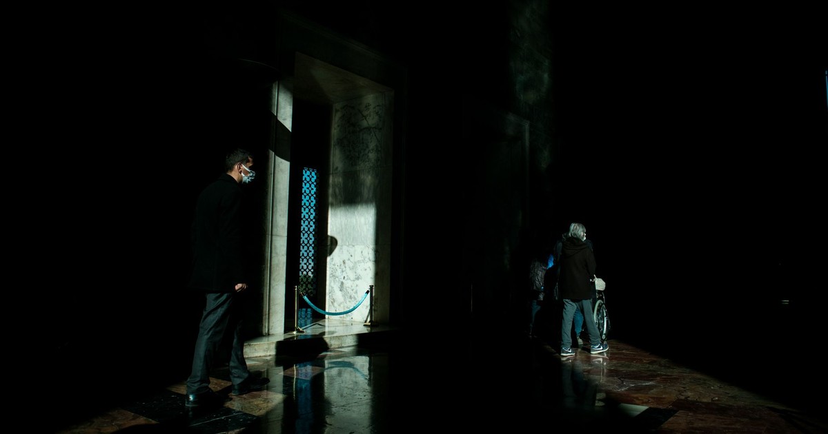 People in a dimly lit corridor casting shadows in an Ankara museum.