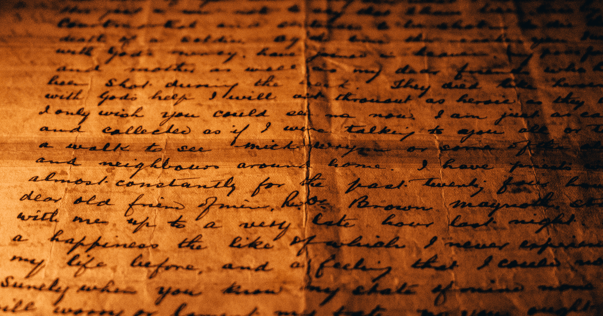 Close-up view of a vintage handwritten letter on textured aged paper.