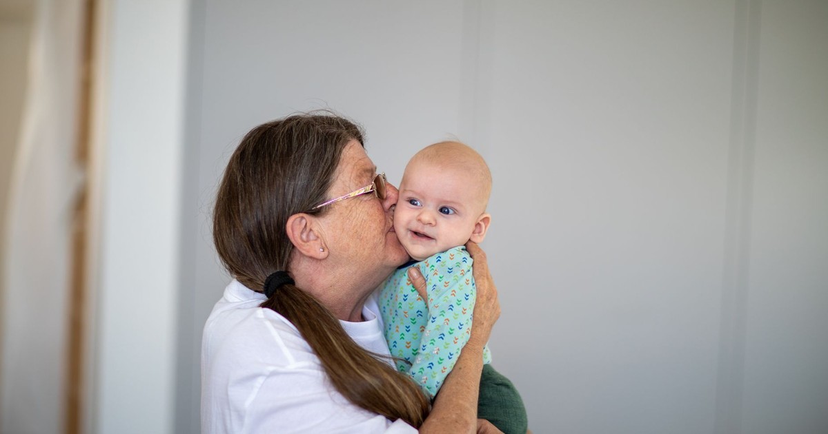 A joyful moment between a loving grandmother and her smiling grandchild indoors.
