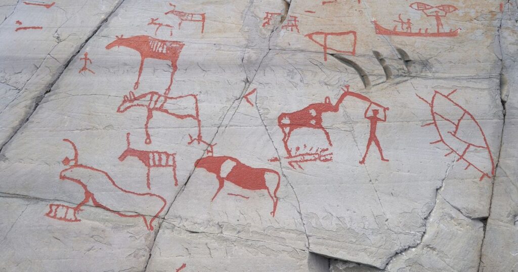 Ancient carvings on rocks depicting animals and humans at Alta, Norway.