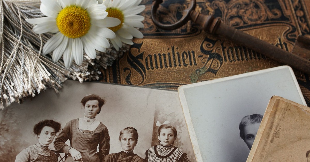 Vintage family photographs with daisies and an antique key evoke memories and nostalgia.
