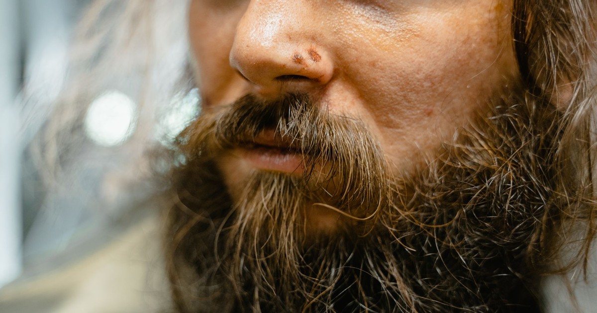 Close-up of a man's face with unkempt beard and facial hair, showcasing texture and detail.