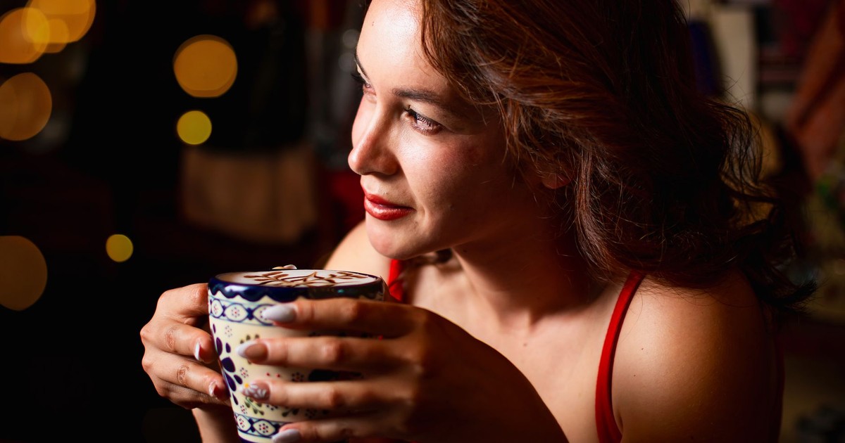 Woman in a warm setting enjoying coffee, creating a relaxing mood.